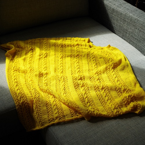 Yellow knitted lace and cable poncho